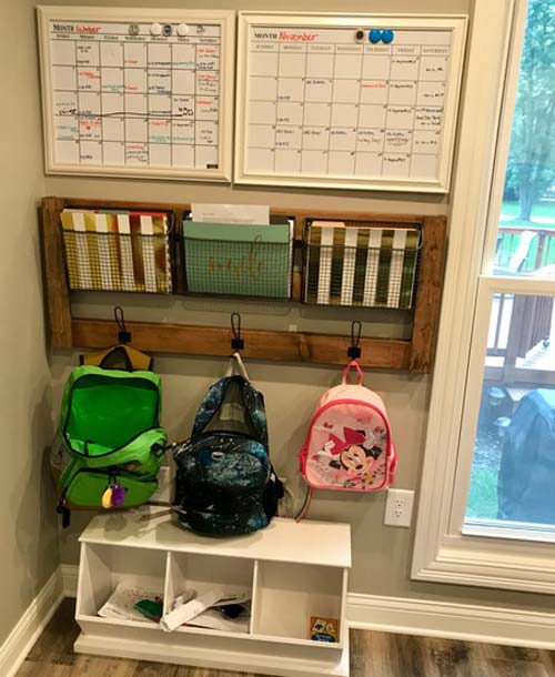 small space with whiteboard calendars, a wall organizer for file folders, cubbies and hooks for backpacks